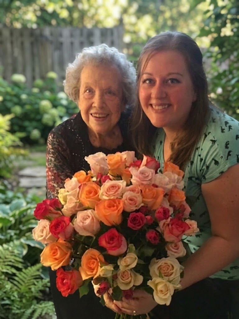 Katherine with her grandmother, holding a roses arrangement Katherine made